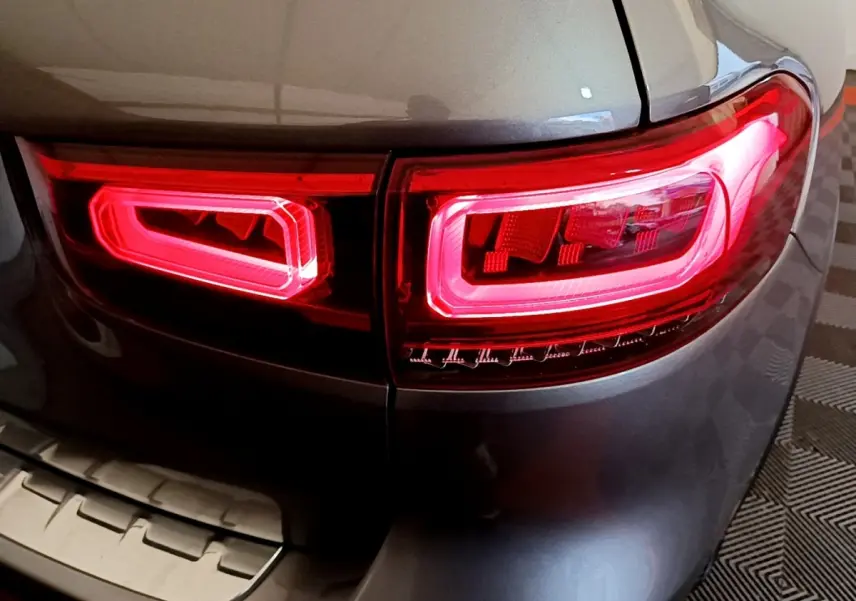 Gros plan sur le feu arrière droit rouge allumé d’un Mercedes GLB 200 d Business Line gris foncé.