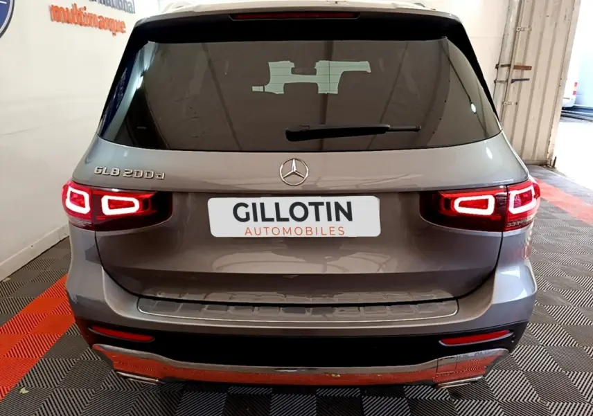 Vue arrière d'un Mercedes GLB 200 d gris foncé avec feux LED allumés dans un showroom.