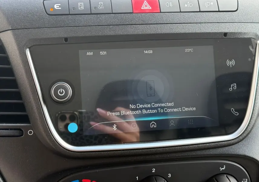 Vue rapprochée de l’écran tactile central et des commandes supérieures du tableau de bord du fourgon Iveco Daily blanc 2026.