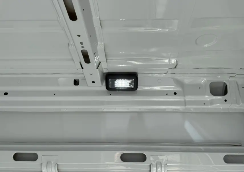 Détail intérieur du plafond blanc du fourgon Iveco Daily 35S18 3.0 V16 Himatic avec éclairage LED encastré.