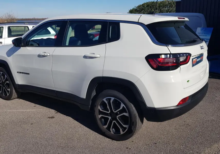 Jeep Compass blanc vu en 3/4 arrière côté gauche, avec jantes alliage 18 pouces et feux arrière LED.