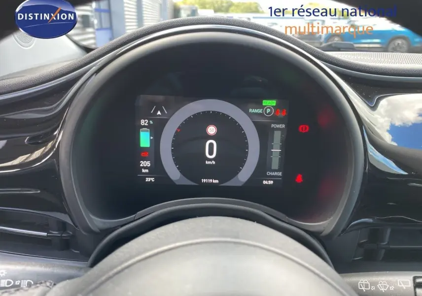Vue rapprochée du tableau de bord numérique noir d’une Fiat 500 électrique 2023, affichant la vitesse et l’autonomie.