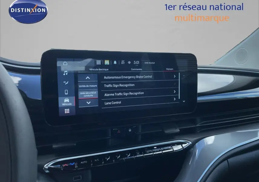 Vue intérieure du tableau de bord de la Fiat 500 électrique 2023, écran tactile central affichant les aides à la conduite.