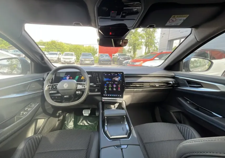 Vue intérieure avant du Renault Austral 200 Esprit Alpine, tableau de bord moderne avec écran tactile vertical et volant multifonctions cuir.