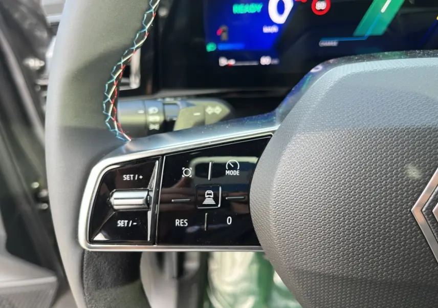 Gros plan sur la partie gauche du volant cuir multifonctions du Renault Austral 200 Esprit Alpine, avec surpiqûres tricolores.
