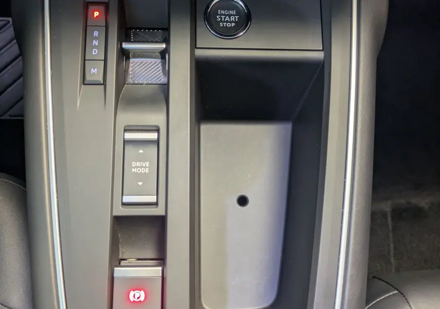 Vue rapprochée de la console centrale noire du Citroën C5 Aircross hybride 2024 avec bouton start/stop et levier de vitesses automatique.