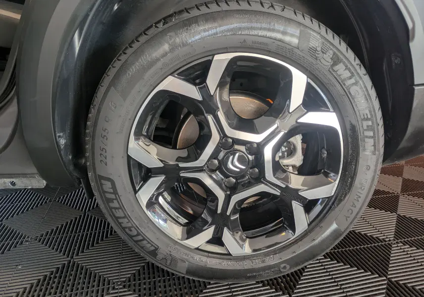 Gros plan sur la roue arrière droite du Citroën C5 Aircross gris platinium avec jante alliage 18 pouces.