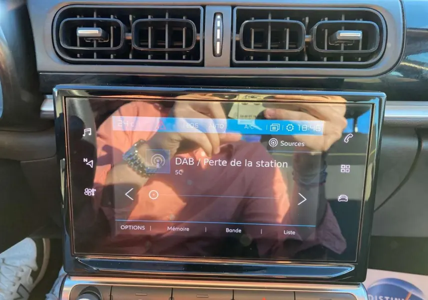 Vue rapprochée de la tablette tactile 7 pouces du tableau de bord de la Citroën C3 gris Artense avec affichage radio DAB en perte de station.