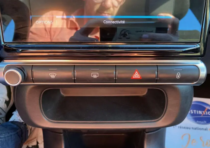 Gros plan sur la console centrale de la Citroën C3 2022 gris Artense, montrant les boutons de désembuage, warning et verrouillage.