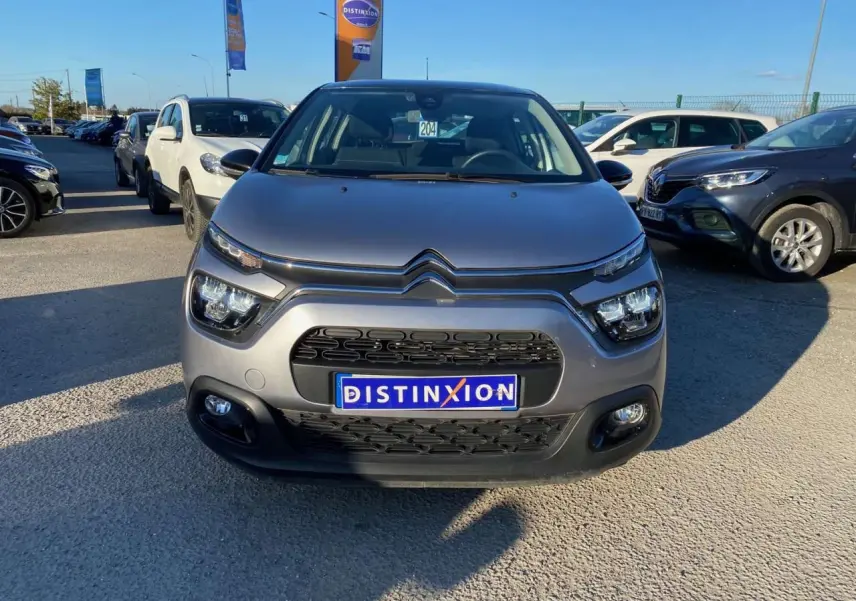Vue frontale d'une Citroën C3 gris Artense 2022 avec calandre noire et phares LED distinctifs.