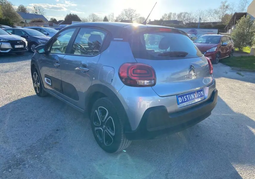 Citroën C3 gris Artense vue 3/4 arrière droit, avec protections latérales noires et jantes spécifiques.