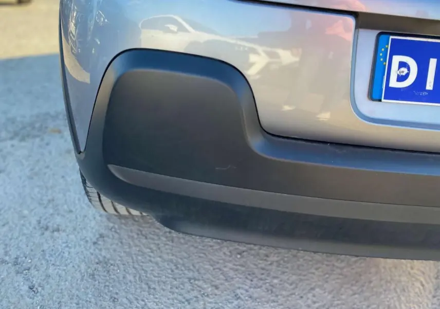 Gros plan sur le pare-chocs arrière gris Artense d'une Citroën C3 2022 avec partie inférieure noire mate.