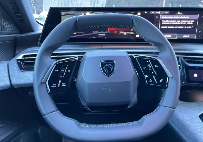 Volant cuir noir du Peugeot 5008 Hybrid 145 Allure Plus 2025 avec commandes intégrées et tableau de bord numérique.