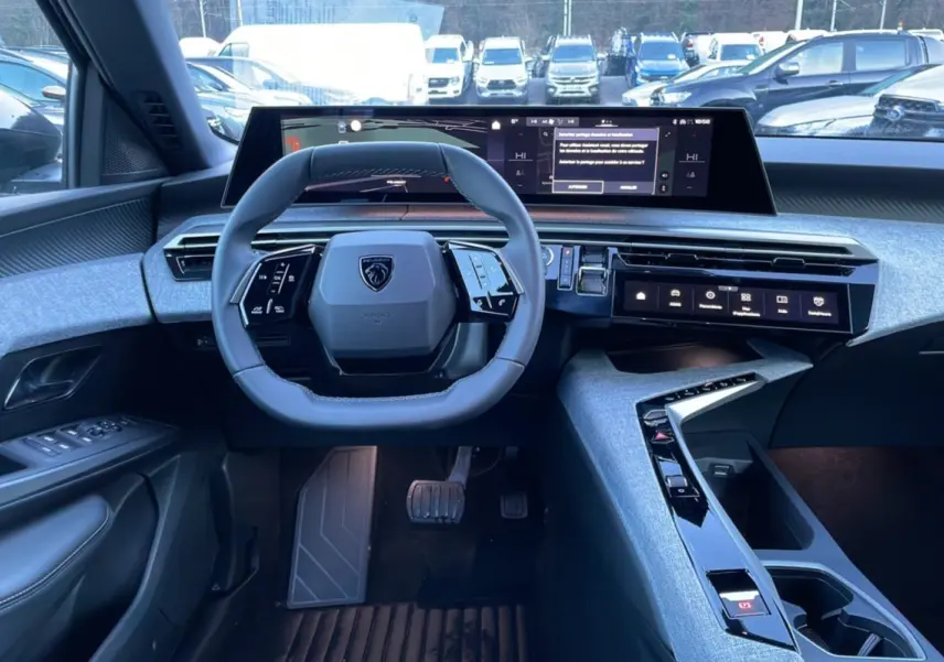 Vue intérieure du poste de conduite du Peugeot 5008 Hybrid 145 Allure Plus 2025, avec volant compact et tableau de bord numérique.