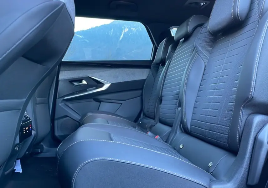 Vue latérale intérieure des sièges arrière en cuir noir avec surpiqûres blanches du Peugeot 5008 Hybrid 2025 gris titane