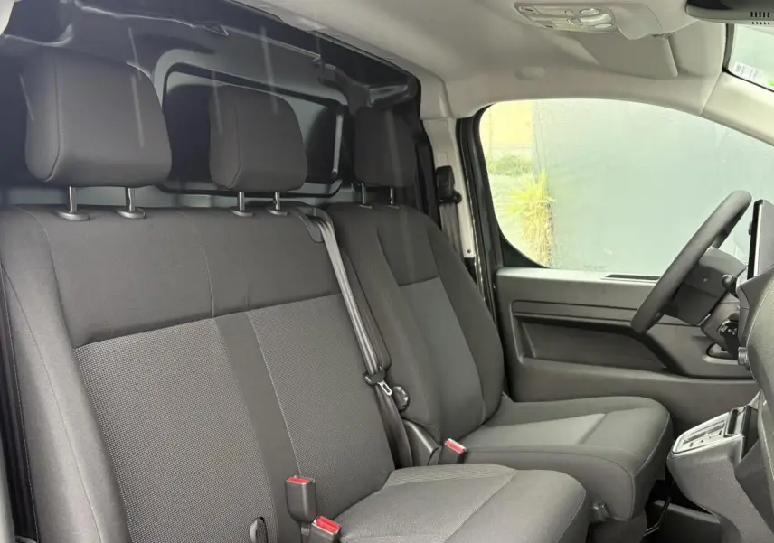 Vue intérieure côté conducteur du Citroën Jumpy 2025, montrant les sièges avant gris et le volant à droite.