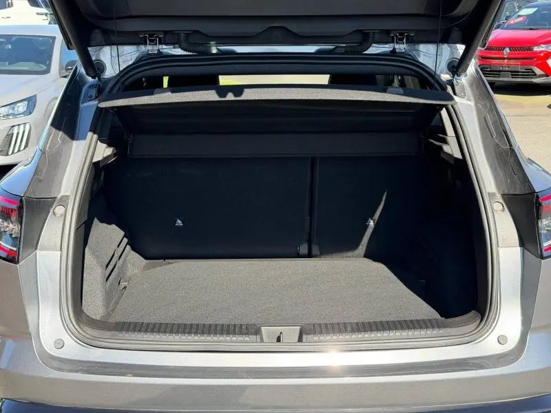 Coffre ouvert vu de l'arrière d'un Renault Austral gris schiste, montrant l'espace de chargement vide.