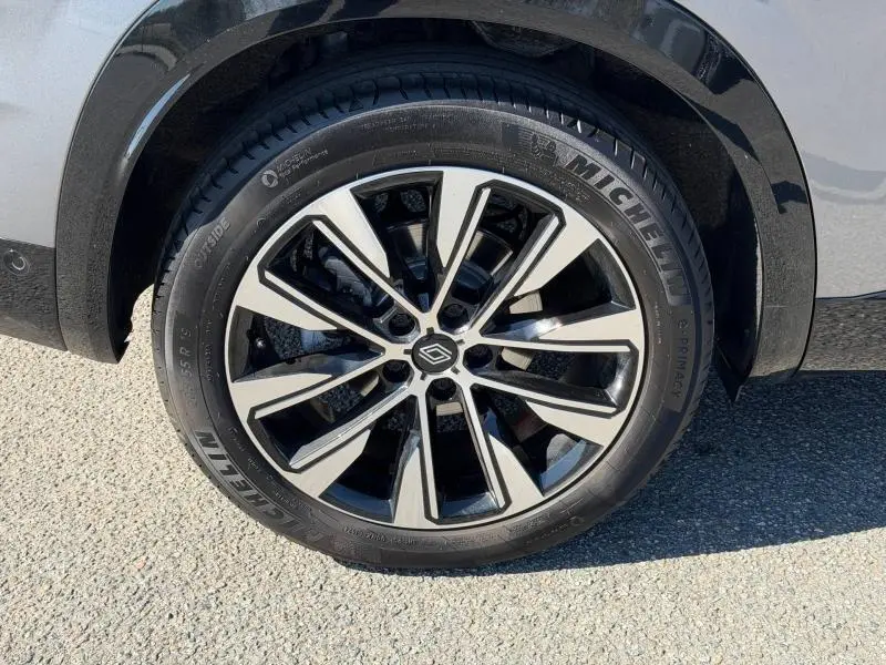 Gros plan sur la jante alu bicolore du côté arrière droit du Renault Austral gris Schiste, avec pneu Michelin visible.