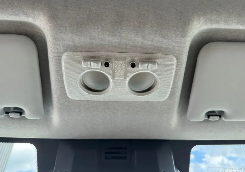 Plafonnier intérieur gris clair avec deux lampes de lecture et pare-soleil dans un Iveco Daily blanc, vue vers le plafond.