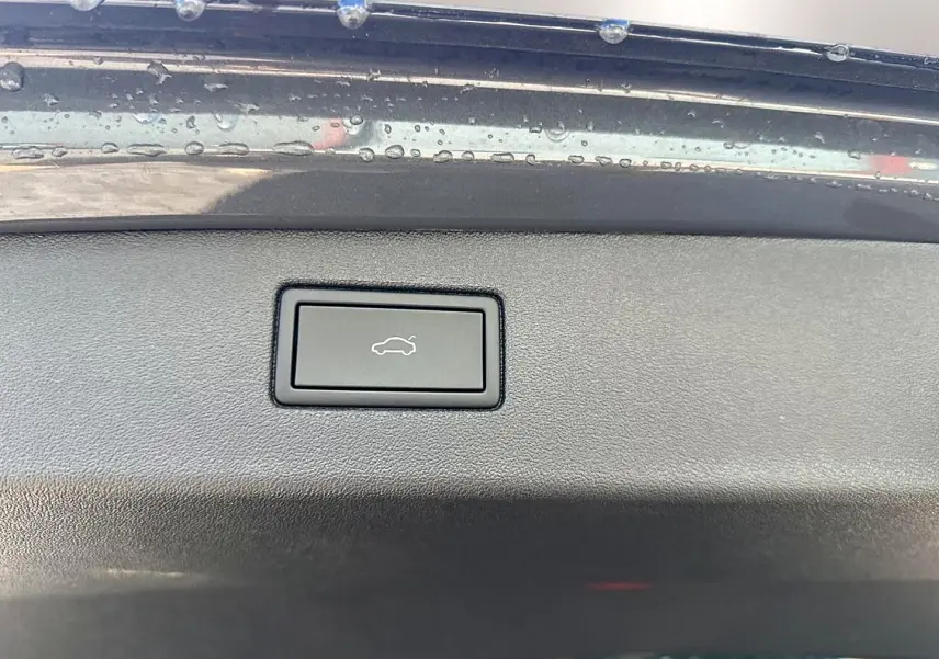 Bouton d'ouverture électrique du coffre sur la partie intérieure du hayon gris dauphin du Volkswagen Tiguan 2024.