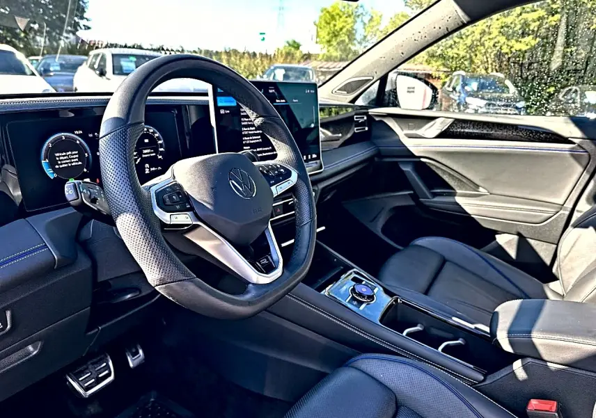 Intérieur avant droit du Volkswagen Tiguan 2024 gris dauphin, volant cuir multifonction et écran tactile central.