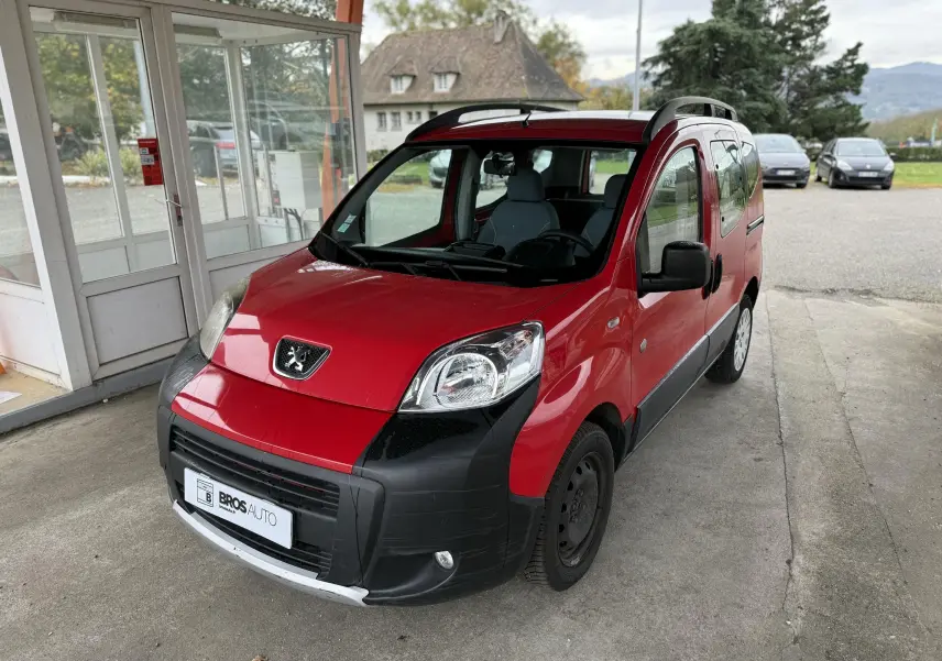 Peugeot Bipper Tepee rouge vue 3/4 avant droit, avec pare-chocs noir et toit ouvrant sous abri.