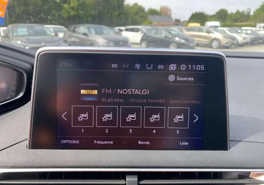 Affichage central tactile du Peugeot 3008 gris platinium, vue intérieure frontale sur l'écran multimédia FM Nostalgie à 11h05