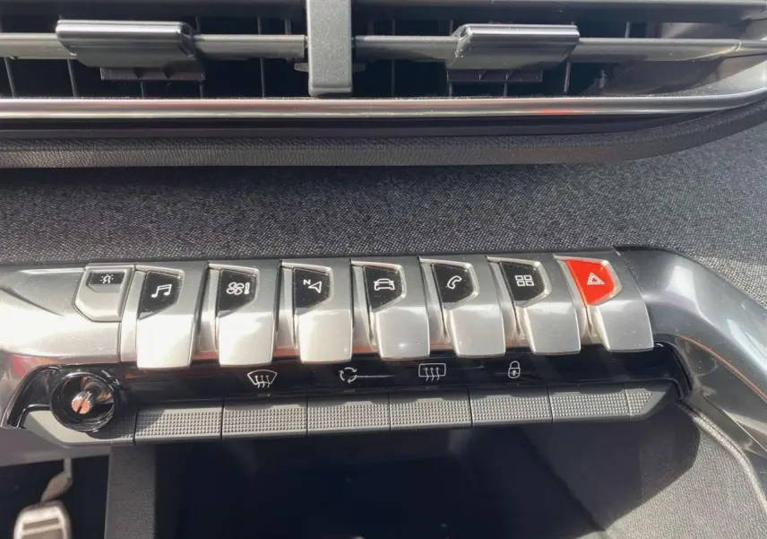 Gros plan sur la rangée de boutons argentés et rouge du tableau de bord du Peugeot 3008 gris platinium, version GT Line 2018.