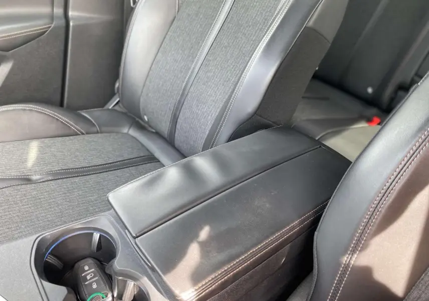 Gros plan sur l'accoudoir central noir et les sièges tissu et cuir du Peugeot 3008 GT Line 2018.