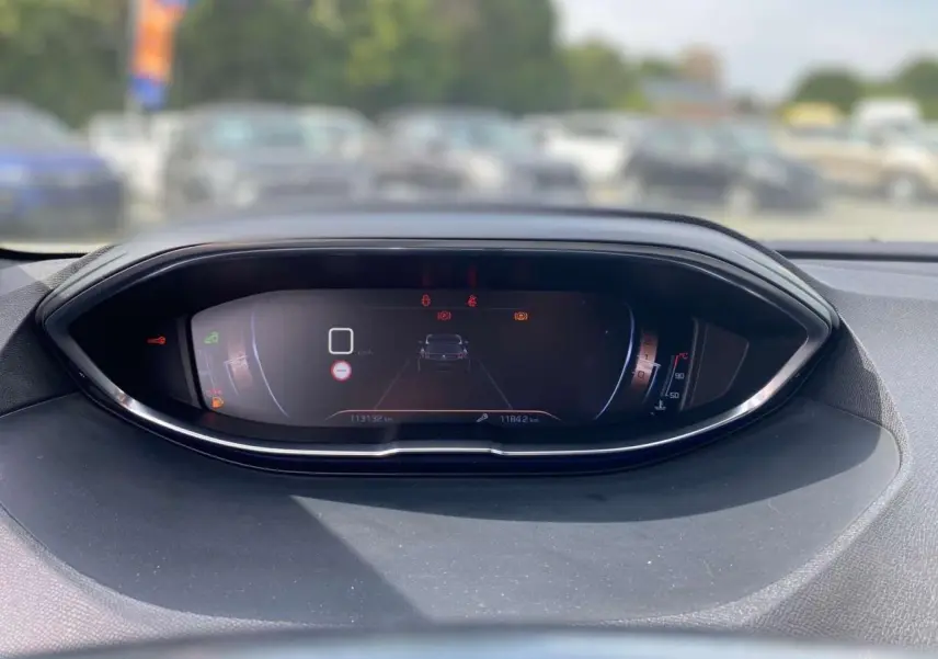 Vue rapprochée du tableau de bord numérique du Peugeot 3008 gris platinium, affichant la vitesse et alertes.