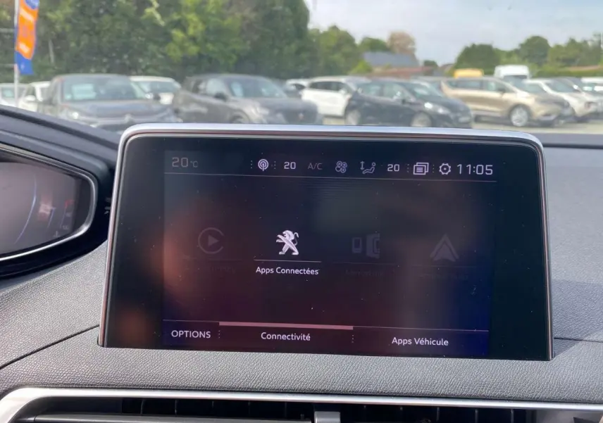 Écran tactile central du Peugeot 3008 GT Line 2018 affichant les options de connectivité, avec vue extérieure floue.