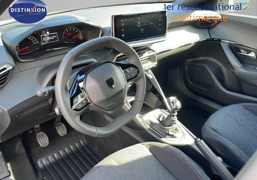 Intérieur de la Peugeot 2008 2025 avec tableau de bord moderne, volant compact et levier de vitesse manuel visible côté conducteur.