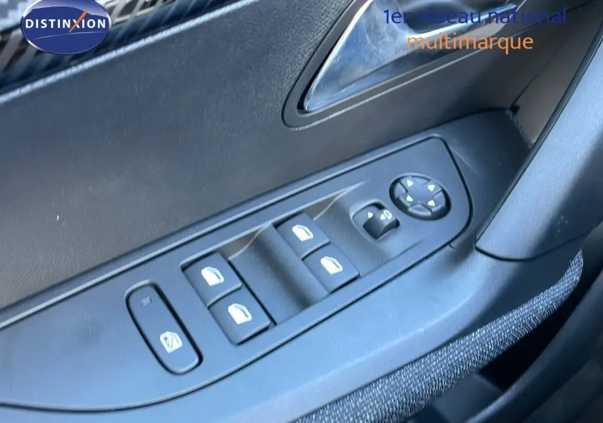 Commande des vitres électriques et réglage des rétroviseurs sur la porte côté conducteur d'un Peugeot 2008 blanc Okenite.