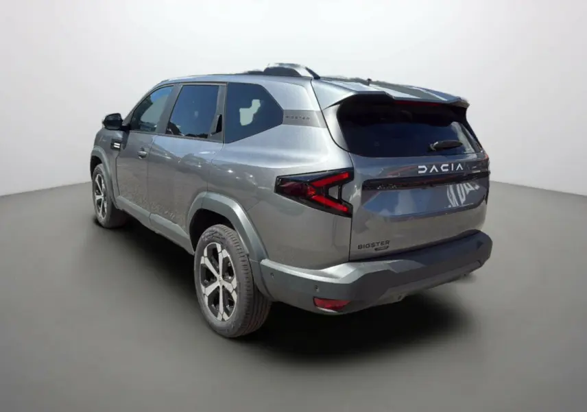 Vue 3/4 arrière droit du SUV Dacia Bigster gris schiste avec feux arrière en forme de flèche et jantes alu 18 pouces.