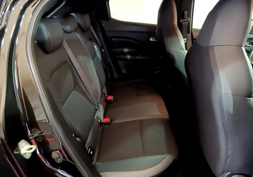 Vue intérieure côté gauche montrant la banquette arrière noire du Nissan Juke Hybrid 143 Business+ 2022.