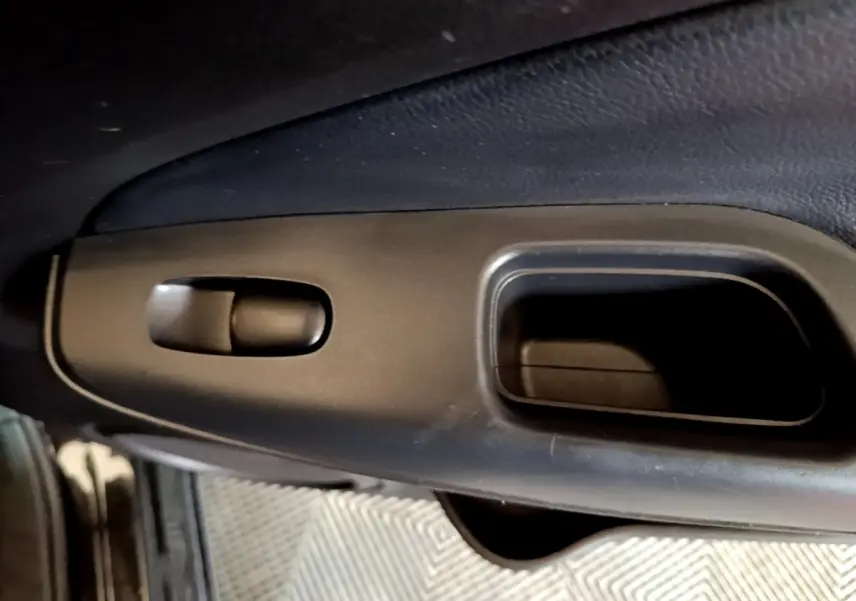 Détail de la poignée intérieure noire côté conducteur du Nissan Juke Hybrid 2022, finition Business+