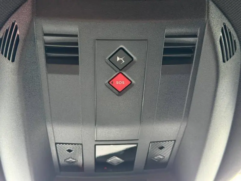 Gros plan sur les commandes au plafond avec bouton SOS rouge dans l’habitacle gris du DS7 E-TENSE 2024.