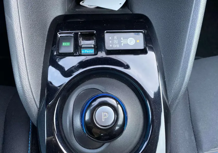 Vue rapprochée de la commande de boîte automatique noire avec bouton parking et touches e-Pedal et ECO d'une Nissan Leaf blanche 2020.