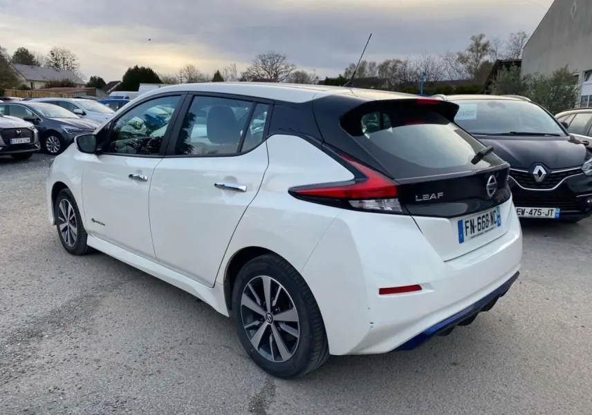 Vue 3/4 arrière droite d'une Nissan Leaf blanche 2020 avec feux arrière distinctifs et toit noir contrastant.
