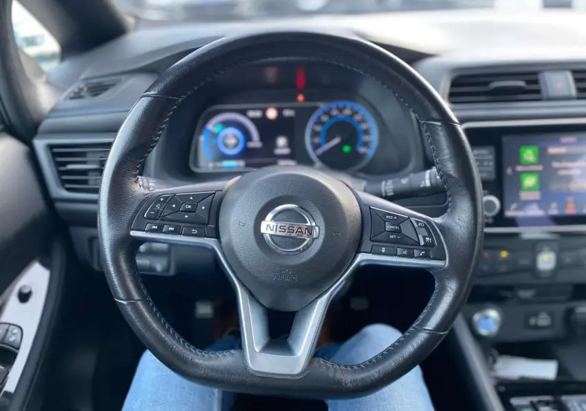 Vue intérieure centrée sur le volant noir du Nissan Leaf 40 N-Connecta 2020 avec tableau de bord et écran tactile visibles.