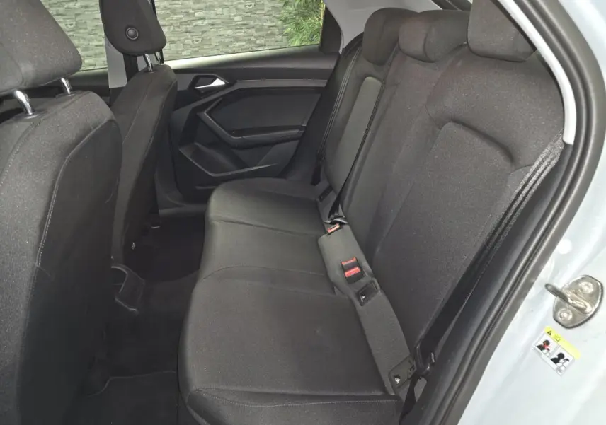 Vue intérieure côté droit des sièges arrière en tissu noir de l'Audi A1 Sportback 2020 avec portières ouvertes.