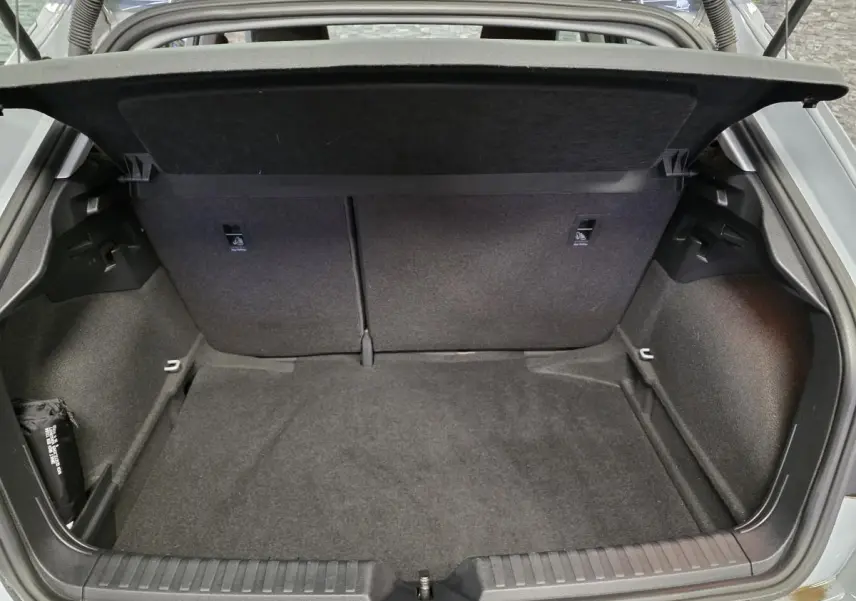 Coffre ouvert vu de l'arrière d'une Audi A1 Sportback gris Manhattan, montrant l'espace de chargement vide et le cache-bagages.