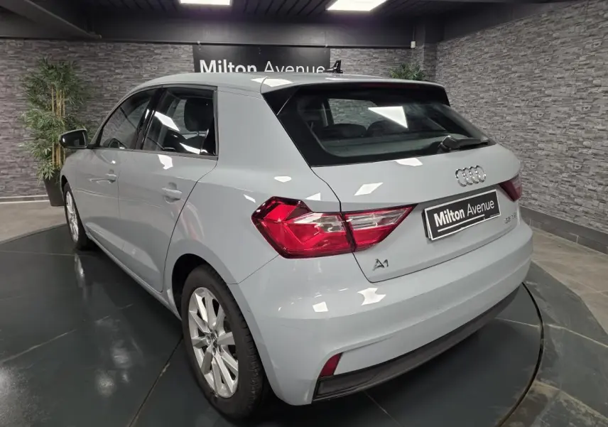 Vue 3/4 arrière droite d'une Audi A1 Sportback gris Manhattan avec jantes aluminium 16 pouces en showroom.