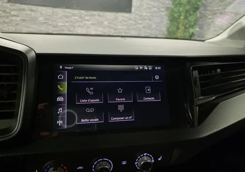 Écran tactile central de l'Audi A1 Sportback 2020 affichant le menu appels, entouré de la console noire et des commandes de climatisation.