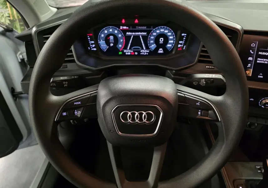 Vue rapprochée du volant noir multifonction et du tableau de bord numérique de l'Audi A1 Sportback 2020.