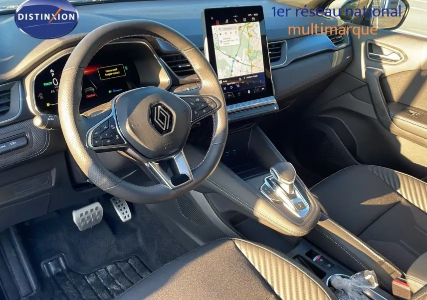 Vue intérieure avant du Renault Captur E-Tech Hybrid 2025, volant multifonction et écran tactile central lumineux.