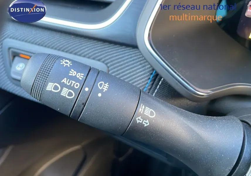 Gros plan sur la commande des phares et clignotants du Renault Captur E-Tech hybride bleu iron métal avec intérieur noir.