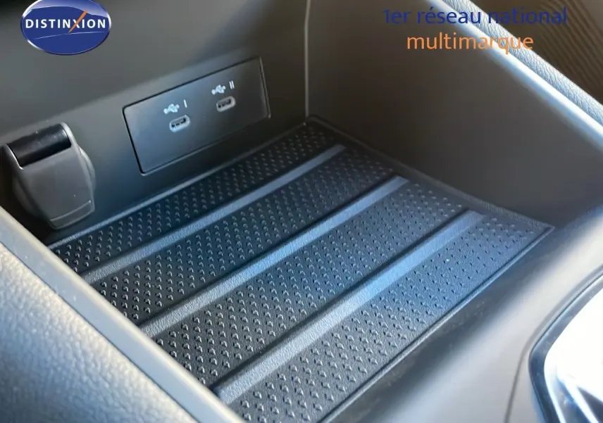 Gros plan sur la console centrale du Renault Captur E-Tech 2025, avec ports USB et surface antidérapante noire.