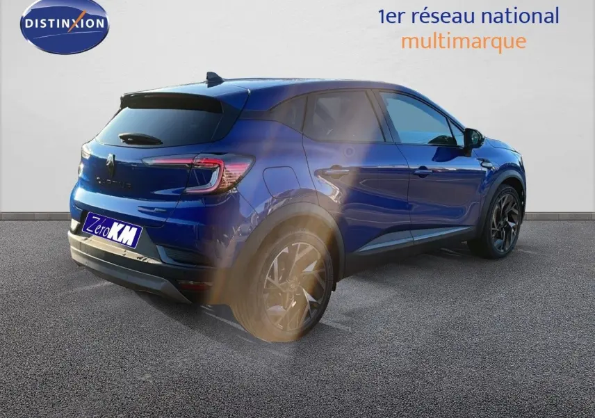 Renault Captur E-Tech hybride 2025 bleu Iron Metal toit noir, vue 3/4 arrière côté gauche avec jantes noires.