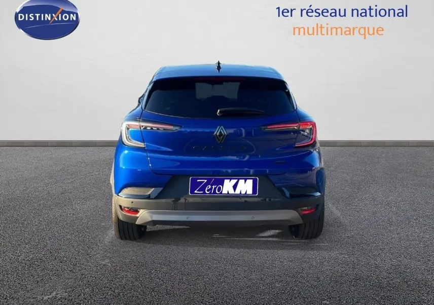 Vue arrière d'un Renault Captur E-Tech hybride bleu Iron Metal avec toit noir, feux arrière LED allumés.